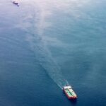 red white and teal cargo ship on water