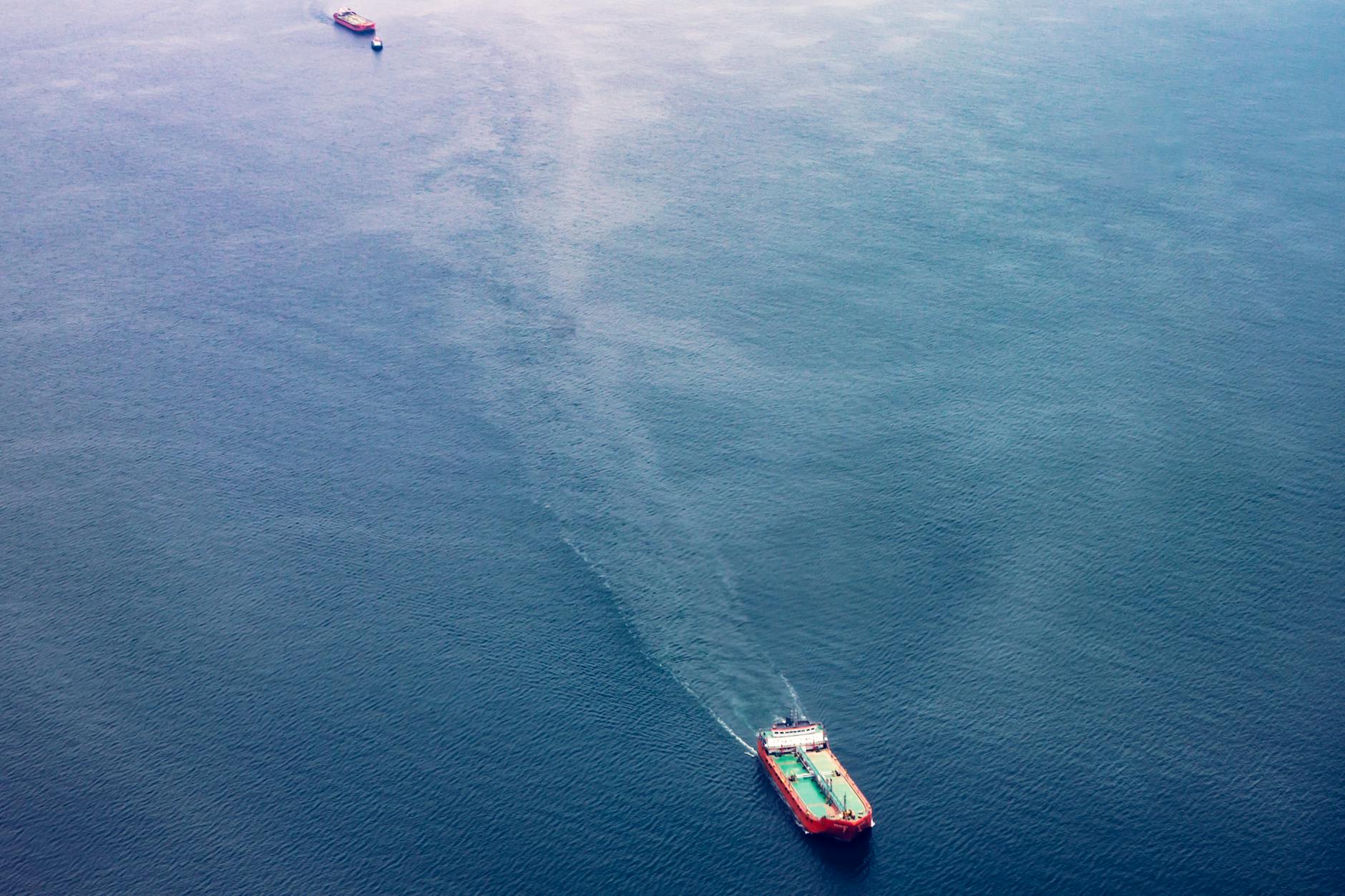 red white and teal cargo ship on water